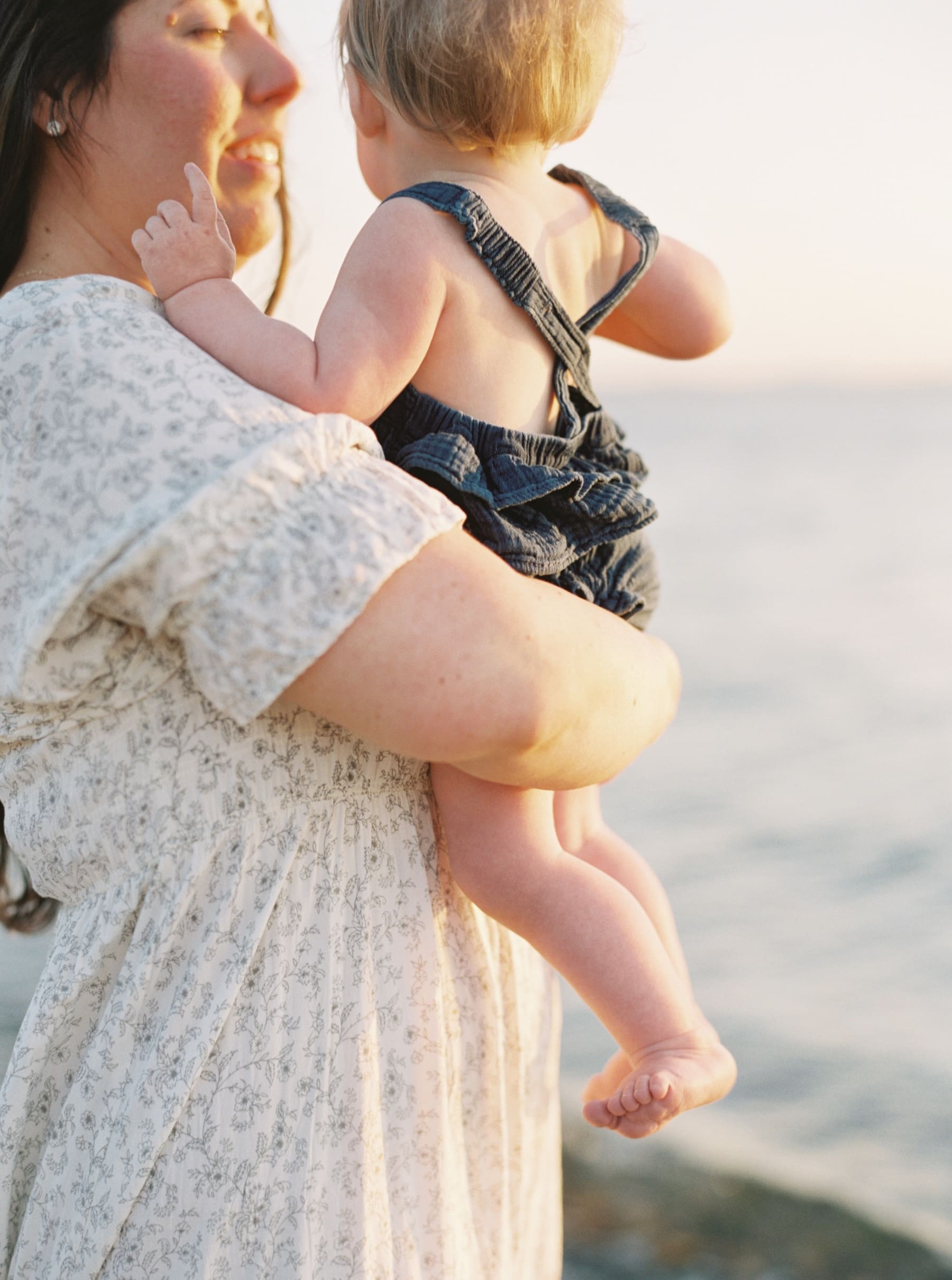 baby legs and feet while mom holds her at beach