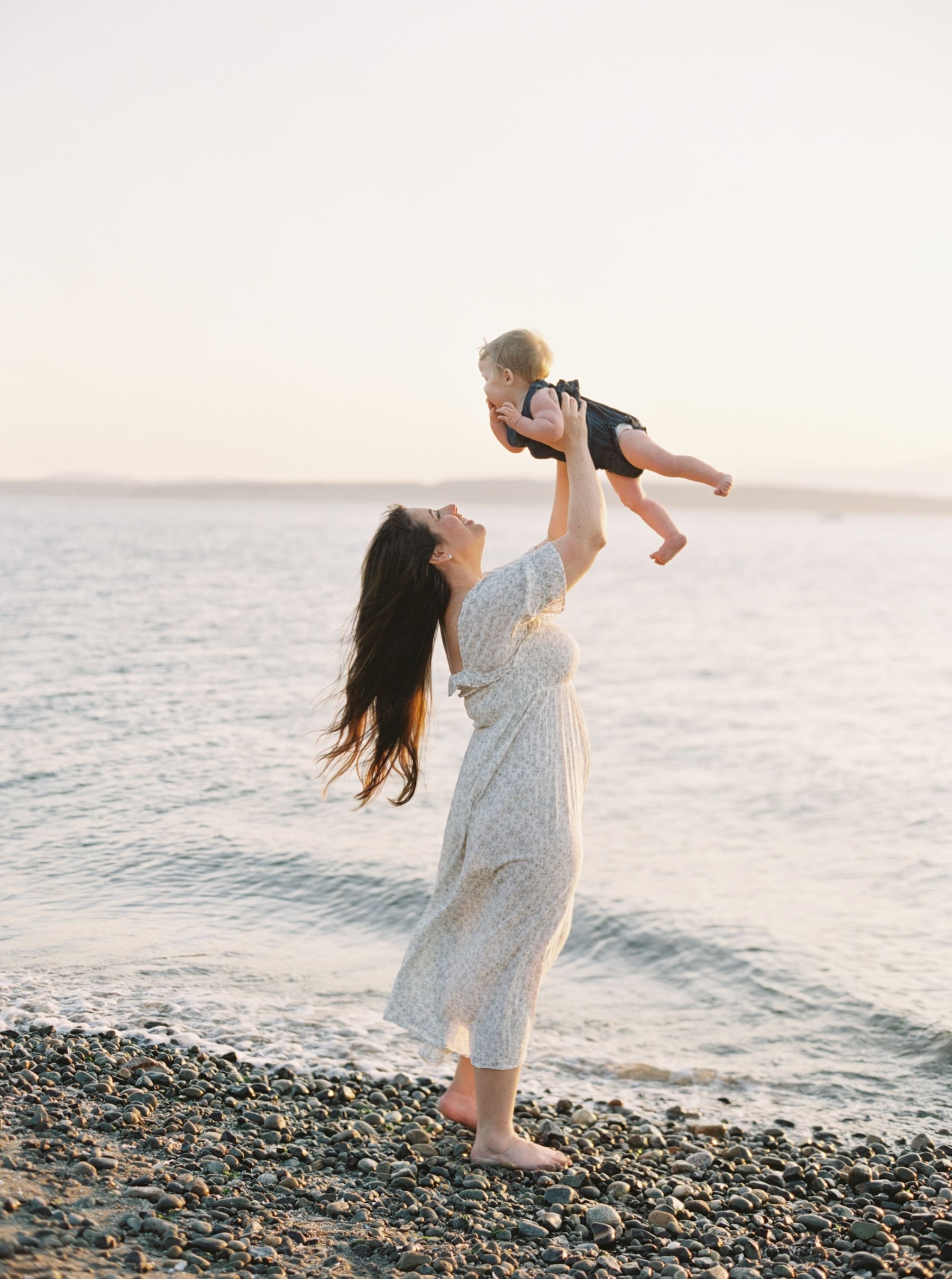 mom throwing baby up above her head for a family photo
