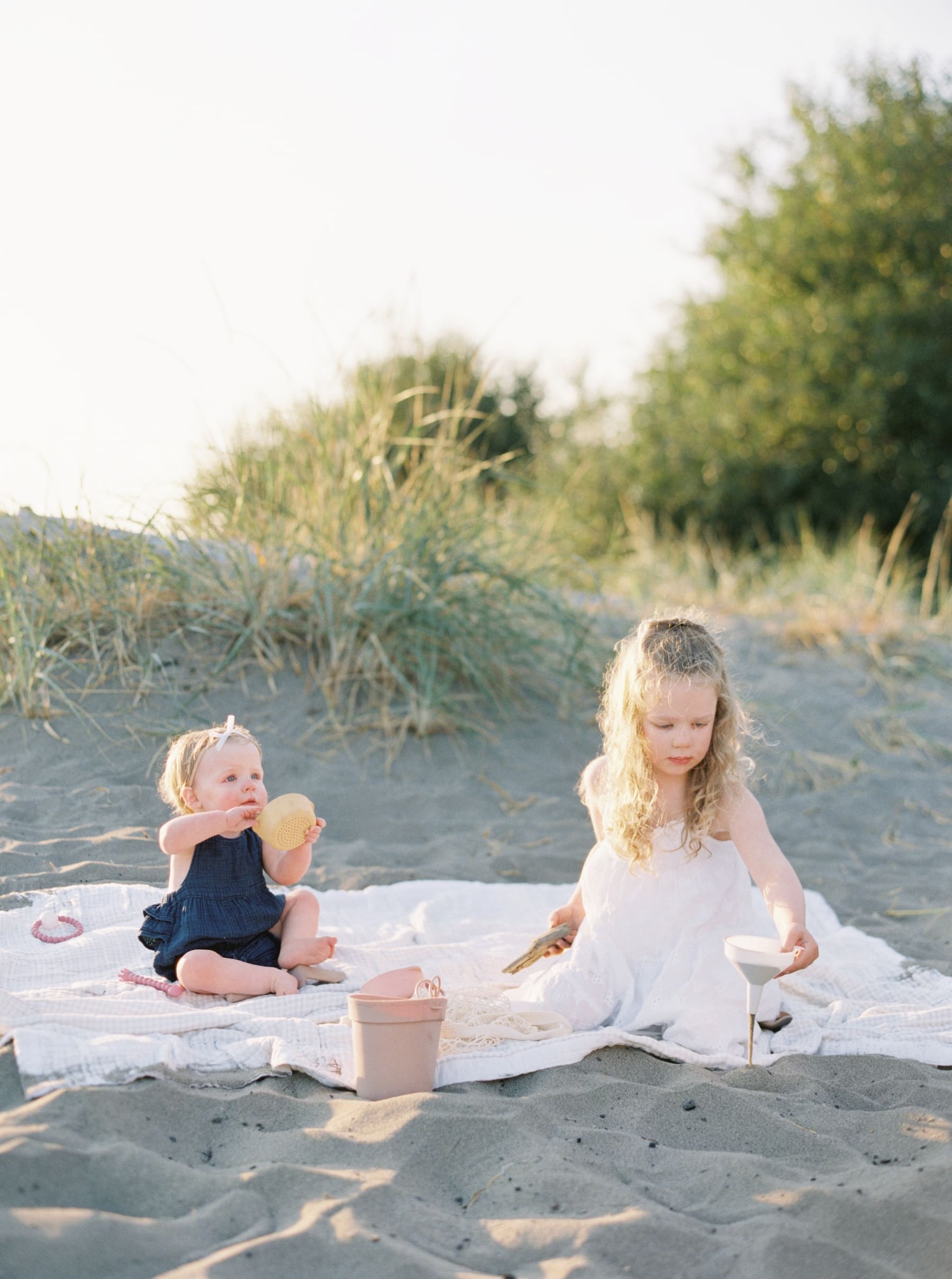 sisters playing in sand at the beach