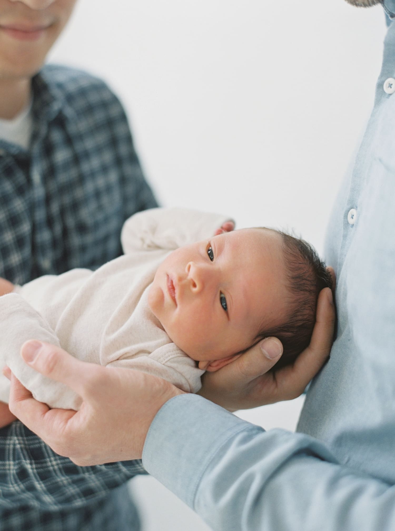 Newborn baby Marshall gently held in parent's hands, soft focus, natural light. Marshall-Newborn-0039.jpg