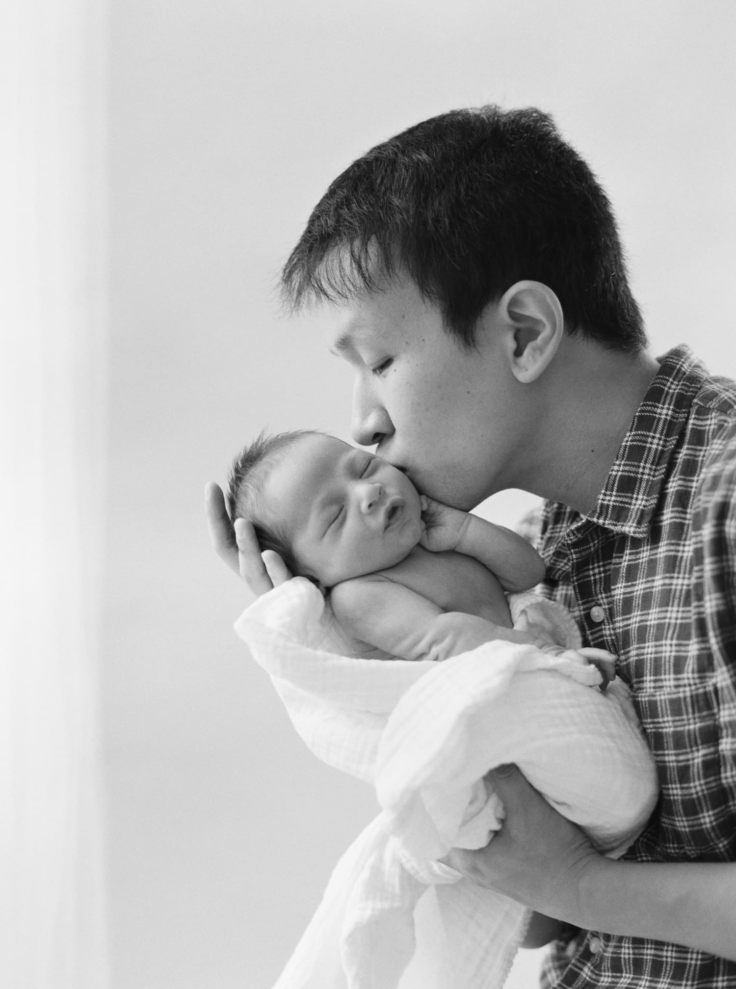 seattle newborn pictures of dad kissing newborns cheek