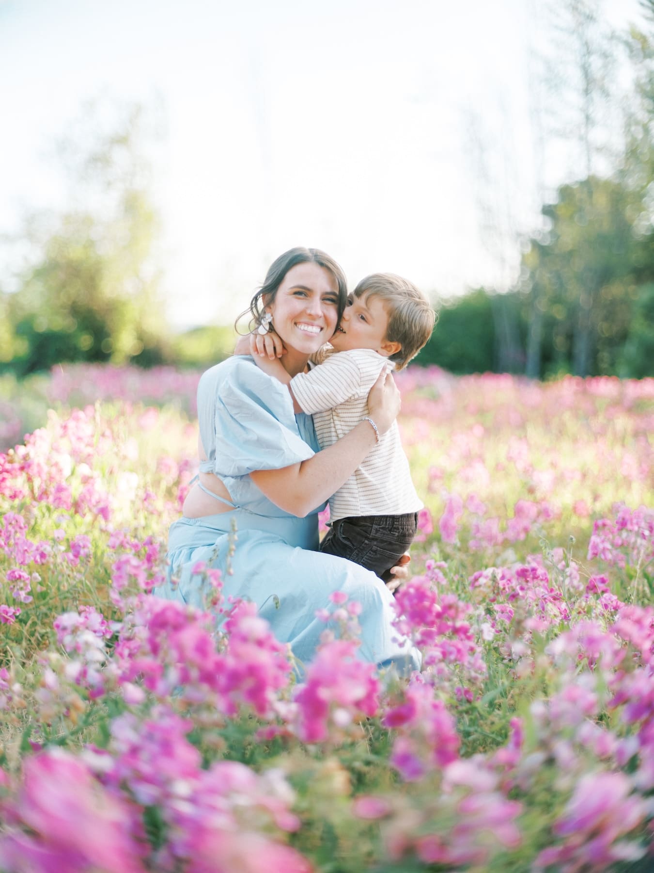mother and son embracing amongst pink wild flowers at discovery park