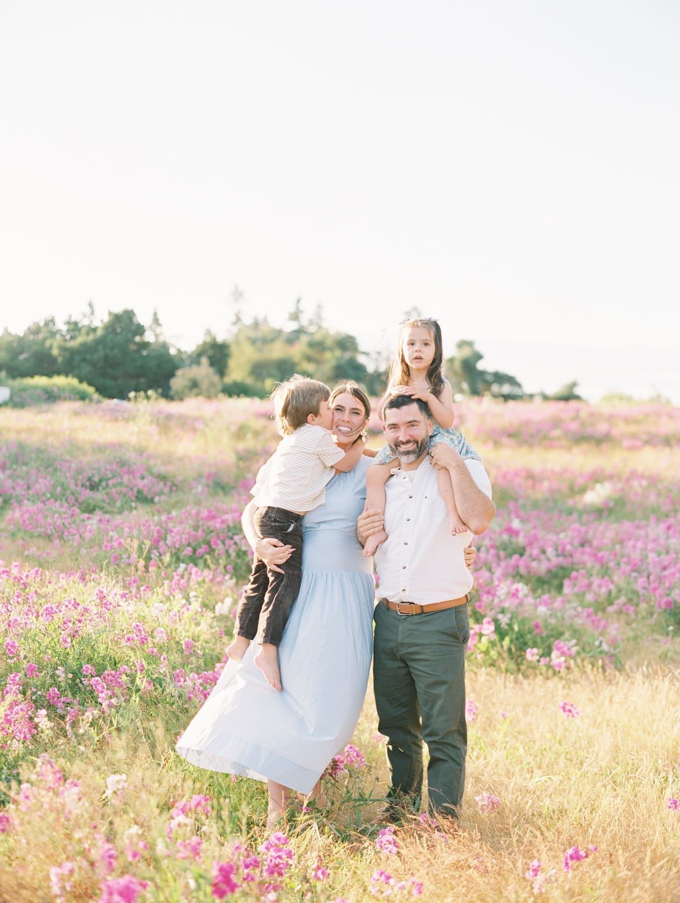 family candidly posing together at discovery park amongst wild flowers